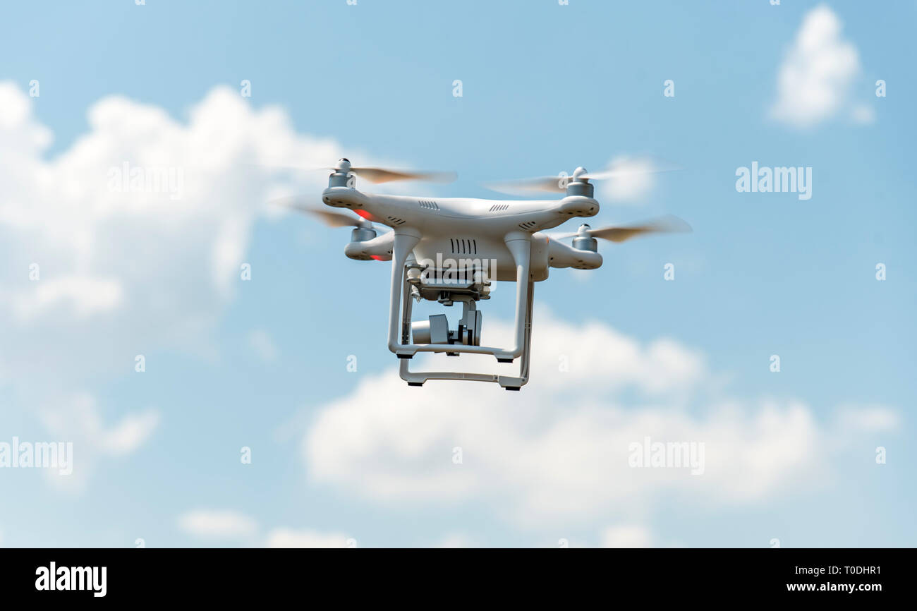 Zumbido con cámara digital volando en el cielo. La tecnología moderna para el vídeo y la fotografía aérea. Foto de stock