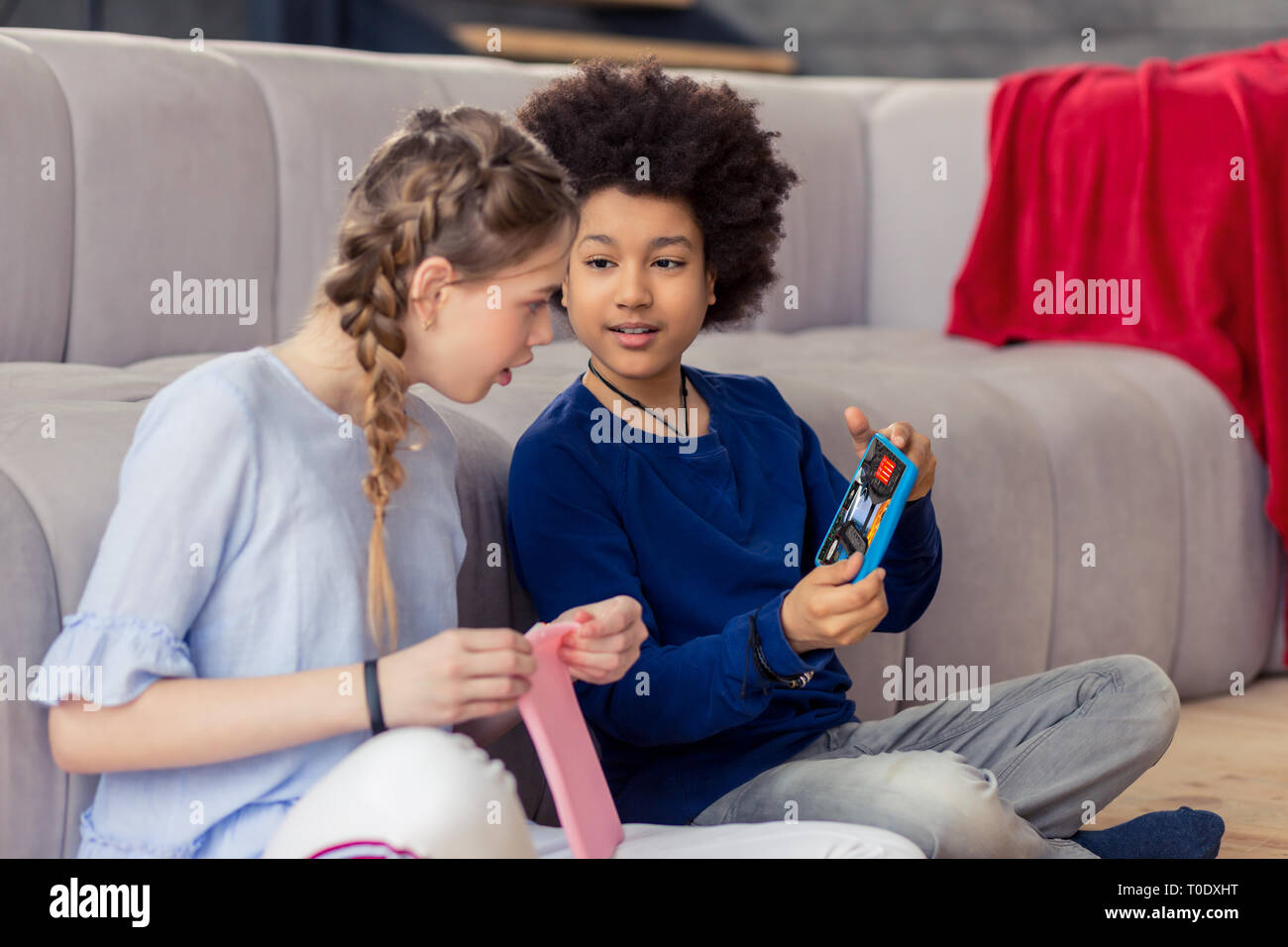 Niños alegres jugando juntos con sus gadgets Foto de stock