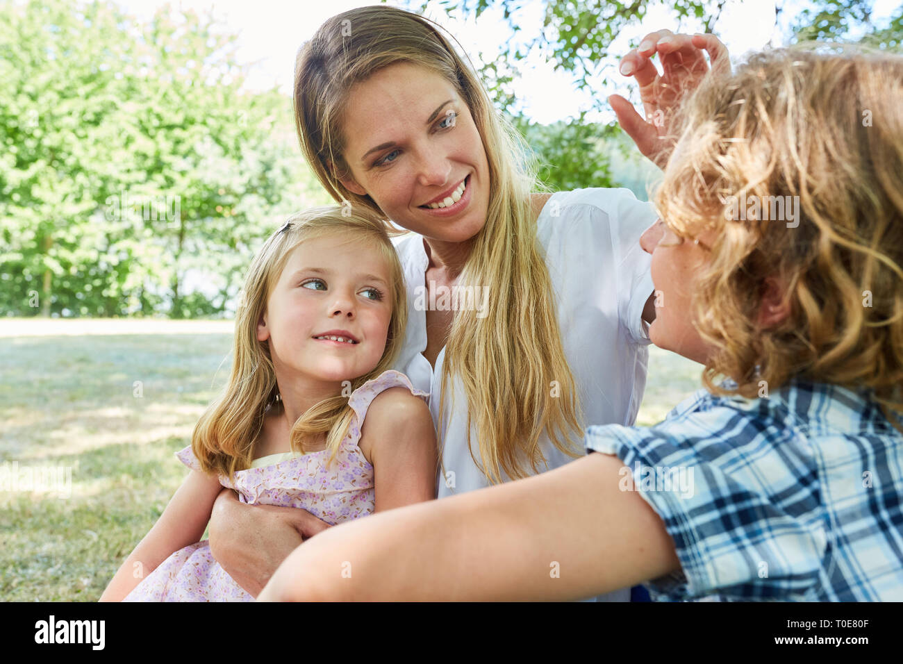 Feliz a la mujer como una madre soltera con dos hijos en el verano en el parque Foto de stock