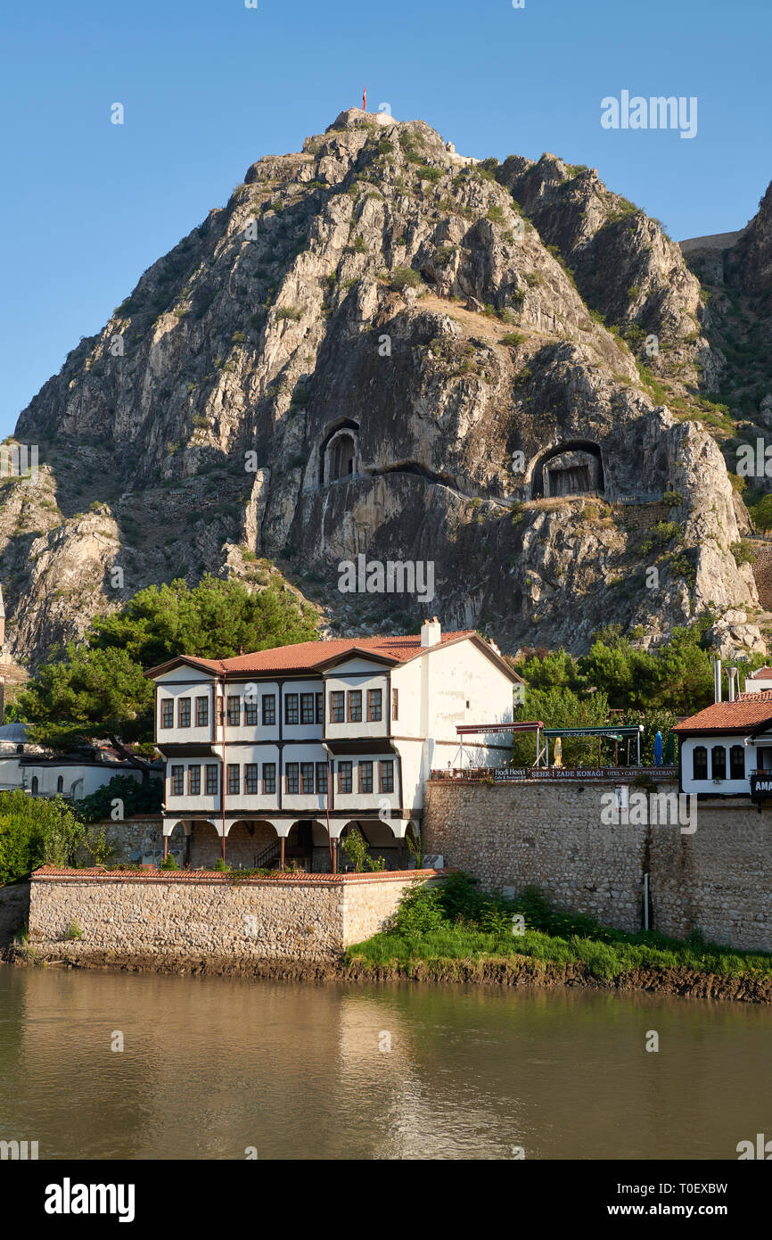 Villas otomano de Amasya a lo largo de las riberas del río Yeşilırmak, debajo del Póntico Royal rock tumbas y alta montaña antigua ciudadela, Turquía Foto de stock