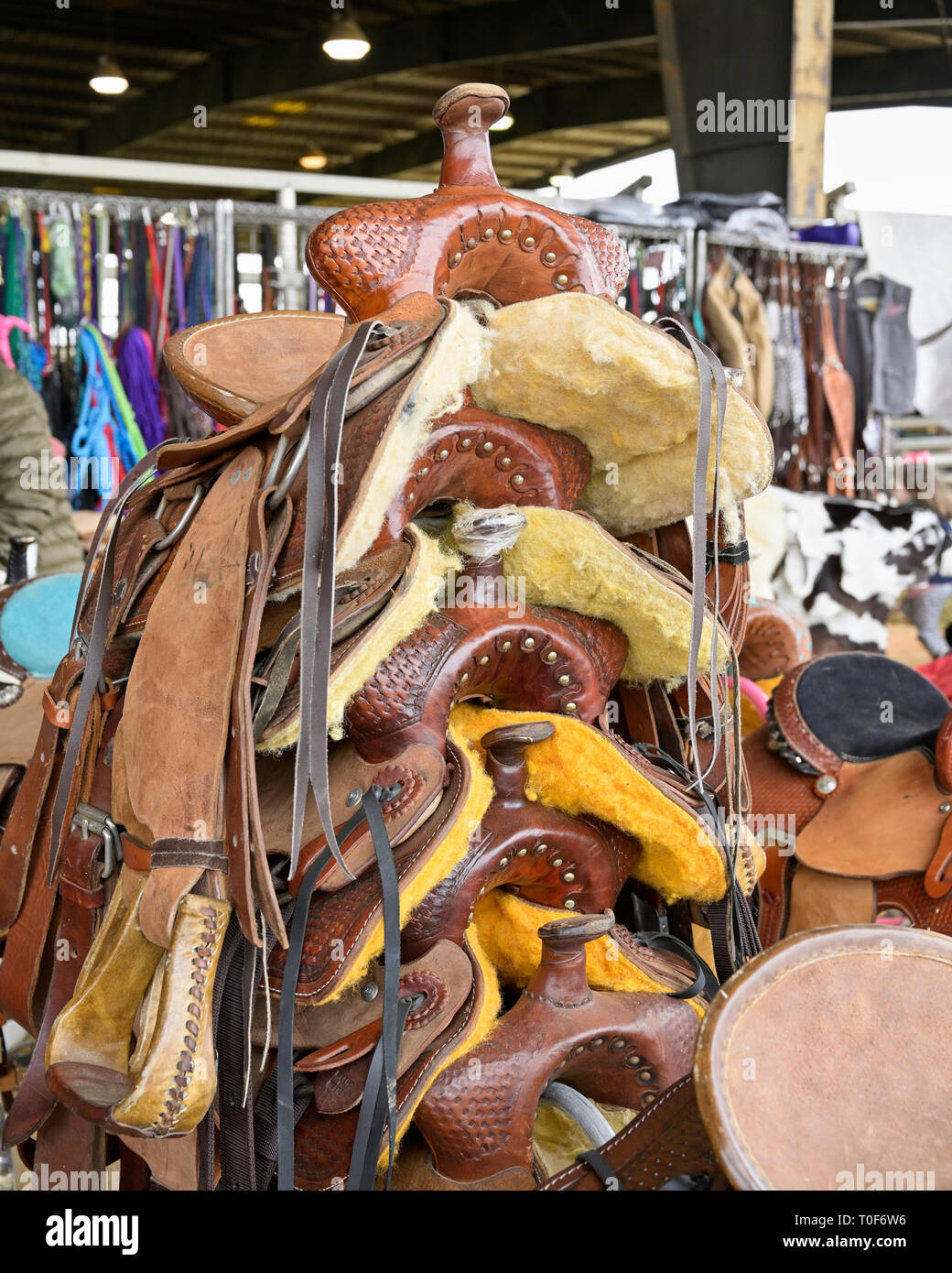 Pila de hechos a mano de cuero occidental monturas de caballos listos para la venta en un rodeo en Montgomery, Alabama, Estados Unidos. Foto de stock