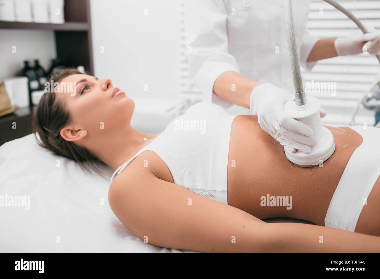 Procedimiento de eliminación de la celulitis en el abdomen, el vientre femenino cavitación masaje Foto de stock