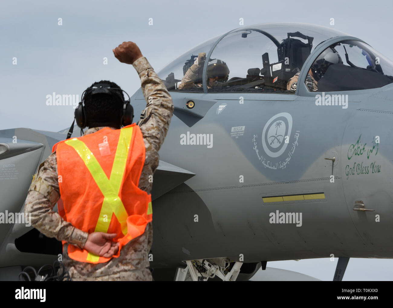 Un mantenimiento de la Fuerza Aérea Real Saudita Aerotécnico de gestos a los F-15SA tripulaciones a través de señales con la mano mientras se preparan para una misión durante la Bandera Roja 19-2 en la Base Nellis de la Fuerza Aérea, 19 de marzo de 2019. Arabia Saudita está participando en el ejercicio junto con otros aliados y está llenando la huelga el papel de la 'Blue vigor." (U.S. Foto de la fuerza aérea por altos Aerotécnico de Isaías Soliz) Foto de stock