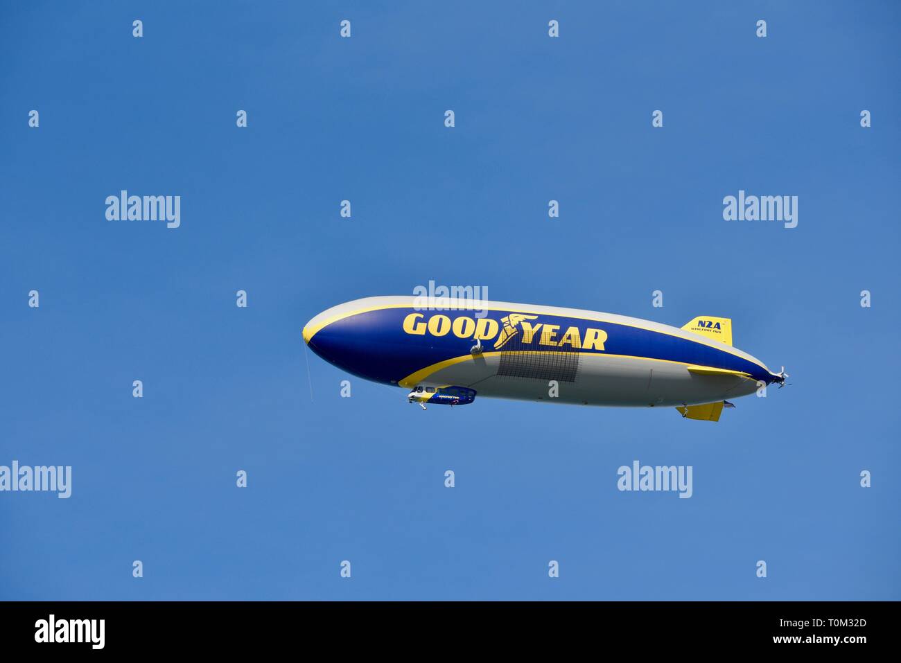 Goodyear famoso dirigible dirigible Soaring sobrecarga en vuelo en el brillante cielo azul, fuera de un evento deportivo, un torneo de golf PGA, San Diego, CA, EE.UU. Foto de stock