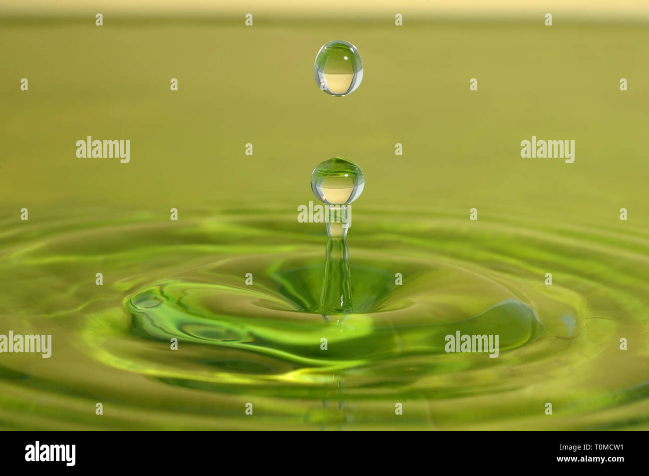 Splash closeup. Gota de lluvia caen sobre la superficie de agua verde. Foto de stock