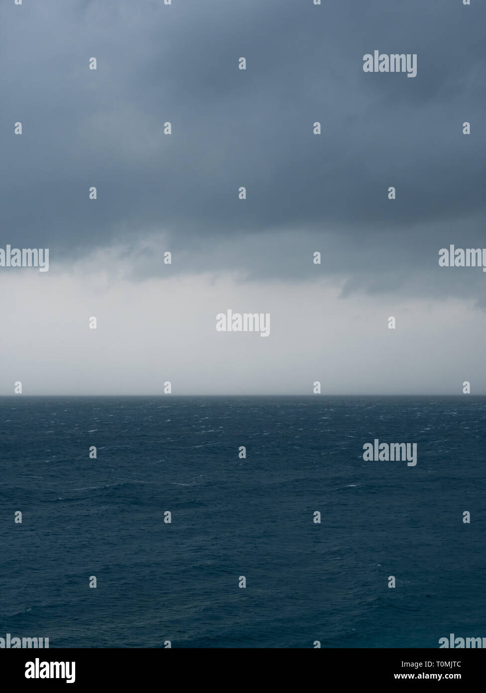 El mal tiempo con nubes de lluvia sobre el mar azul Foto de stock