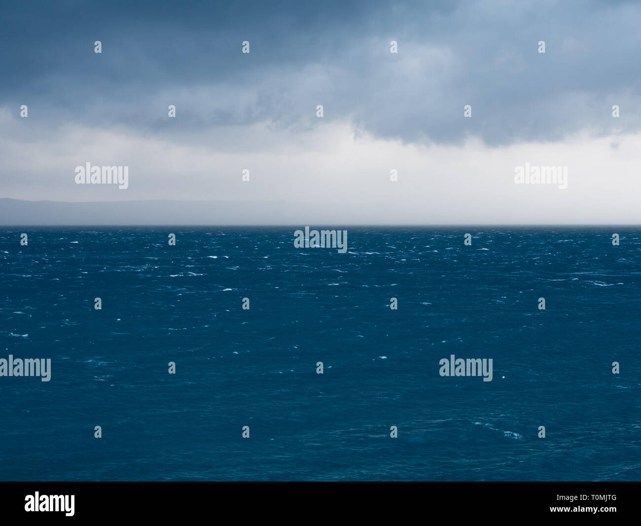 El mal tiempo con fuertes vientos y lluvias de nubes sobre el mar azul paisaje Foto de stock