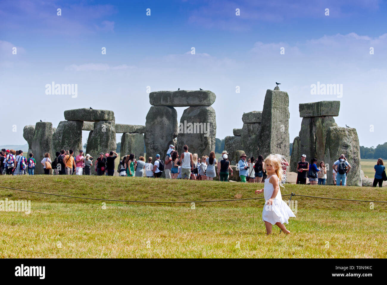 Europa, Reino Unido, Inglaterra, Wiltshire. Niña caminando alrededor de Stonehenge en el verano. Foto de stock