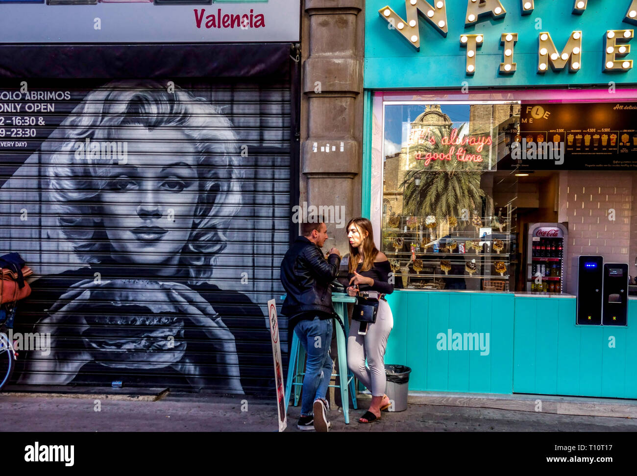 Arte callejero de Valencia Ciudad vieja con Marilyn Monroe comiendo hamburguesa calles valencianas graffiti España escena de la vida joven pareja ciudad Foto de stock