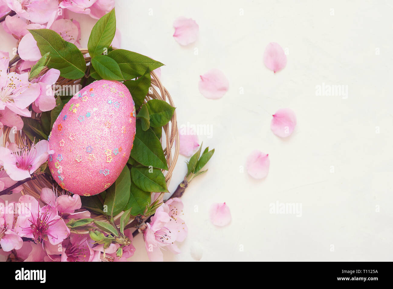 Rosa speckled huevo en nido de pájaro , La Pascua decoraciones festivas , antecedentes concepto de Pascua Foto de stock