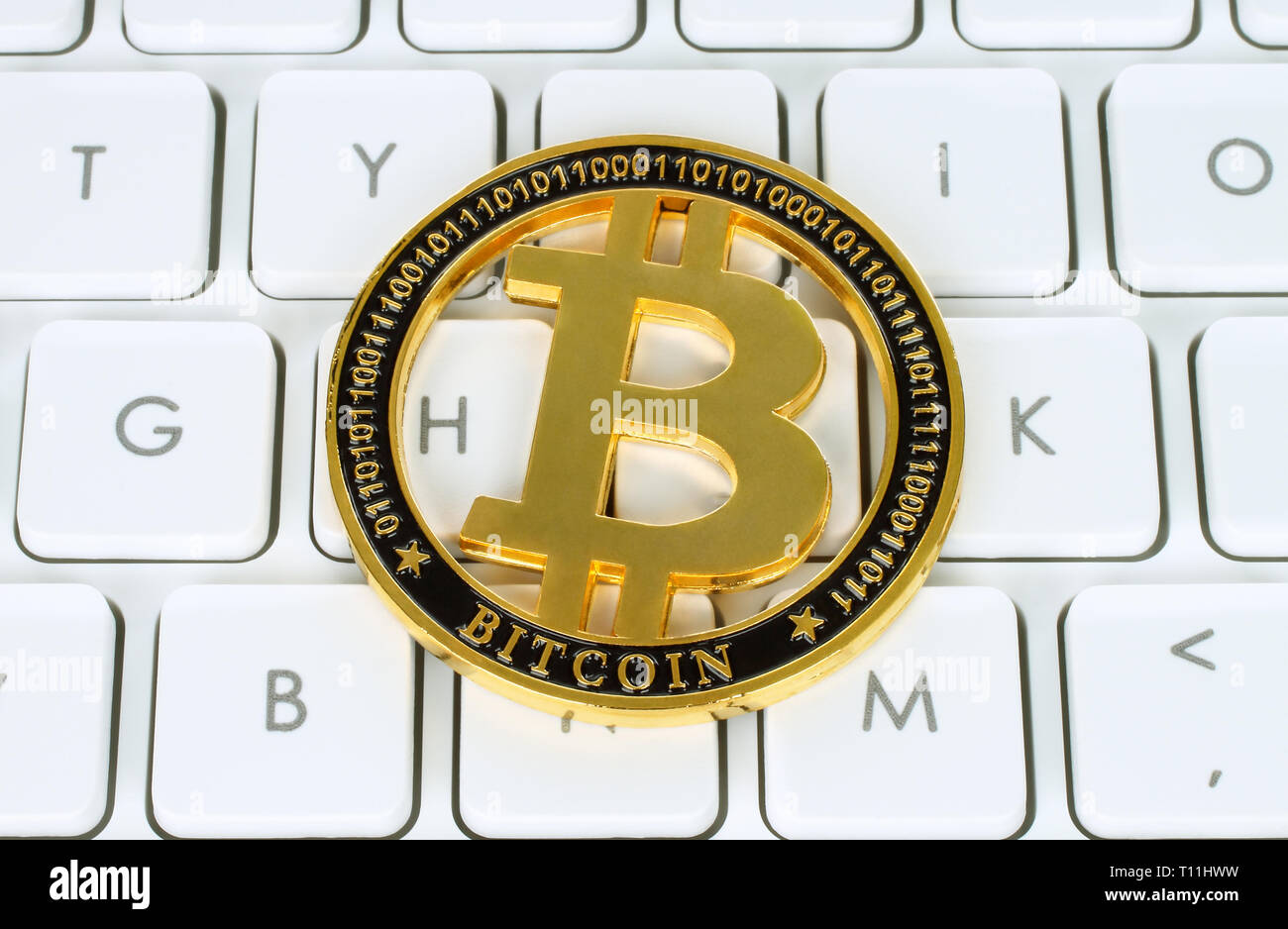 Moneda cryptocurrency Bitcoin sobre blanco teclado cerca de fondo Foto de stock