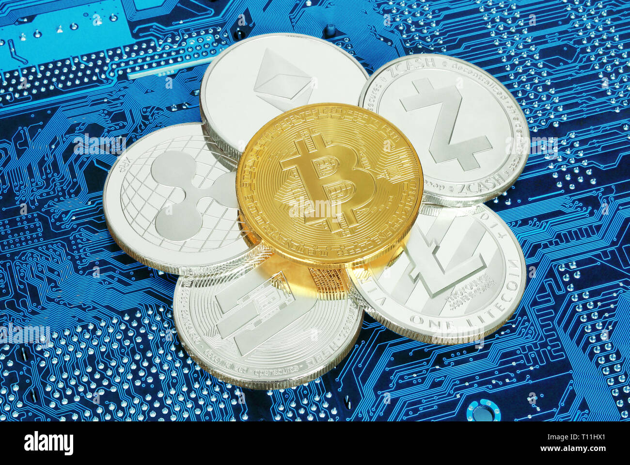 Cryptocurrency monedas en la placa del circuito cerca de fondo Foto de stock