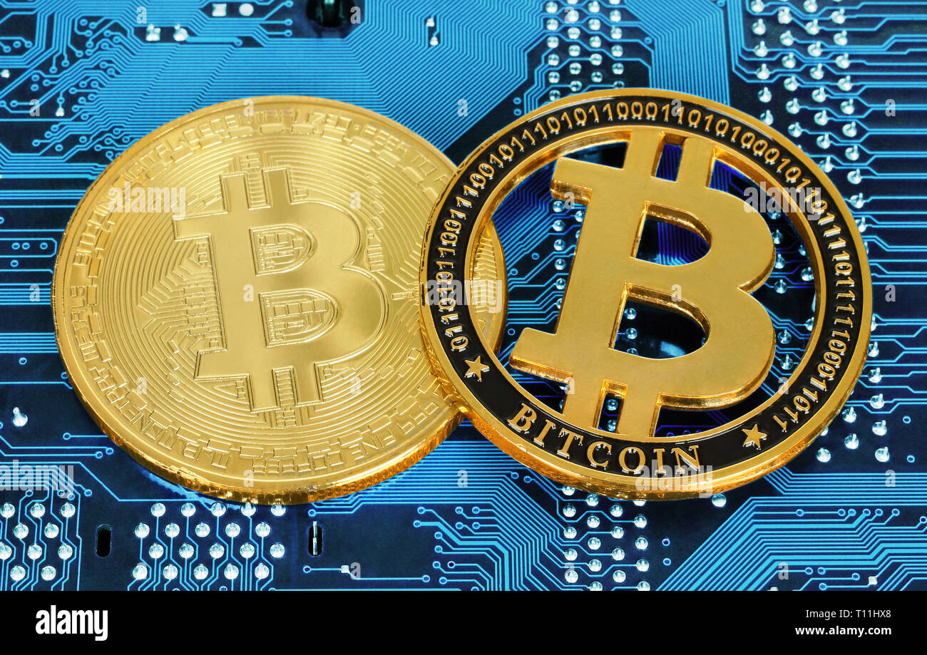 Cryptocurrency Bitcoin monedas en la placa del circuito cerca de fondo Foto de stock
