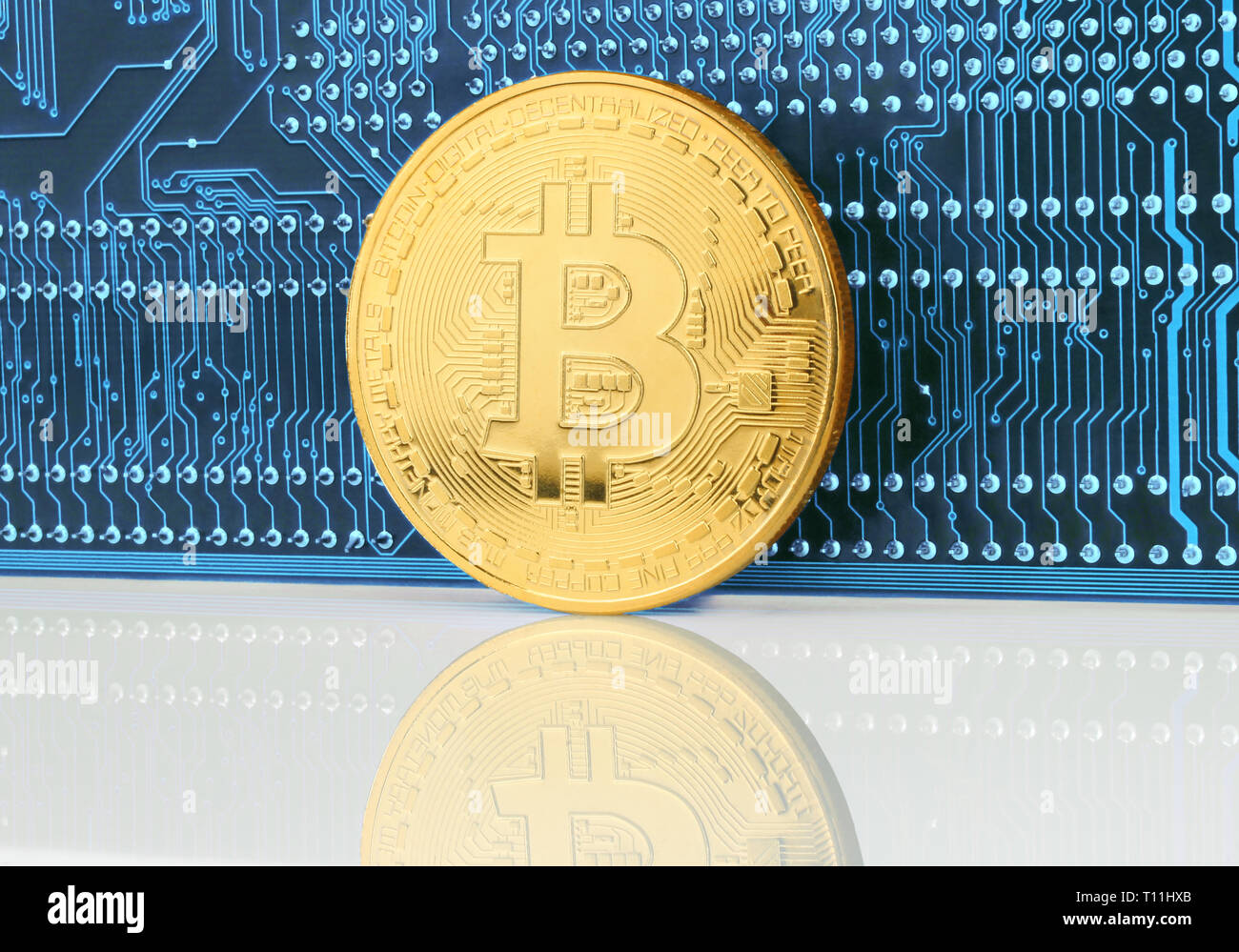 Moneda cryptocurrency Bitcoin en la placa del circuito cerca de fondo Foto de stock