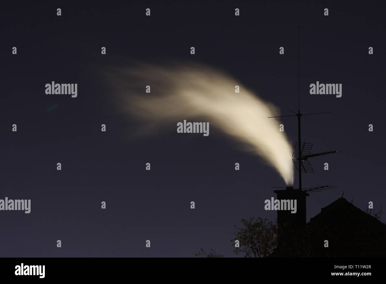 La exposición a largo plazo de una chimenea en la noche con la emisión de humo Foto de stock