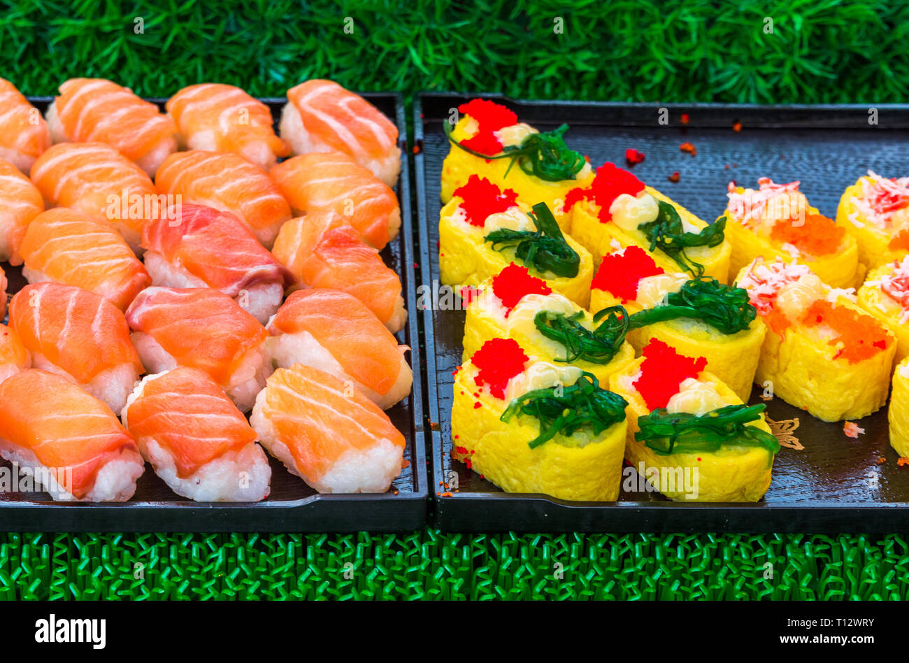 Rollos de sushi japonés manjar. Comida tradicional japonesa de arroz y pescado o marisco. Un conjunto de deliciosos manjares en un día de mercado en Tailandia, un Foto de stock