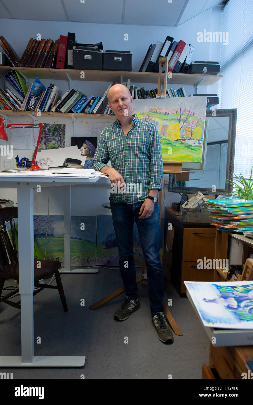 Un ilustrador artístico creativo fotografiado en su interesante estudio / espacio de trabajo en su escritorio Foto de stock