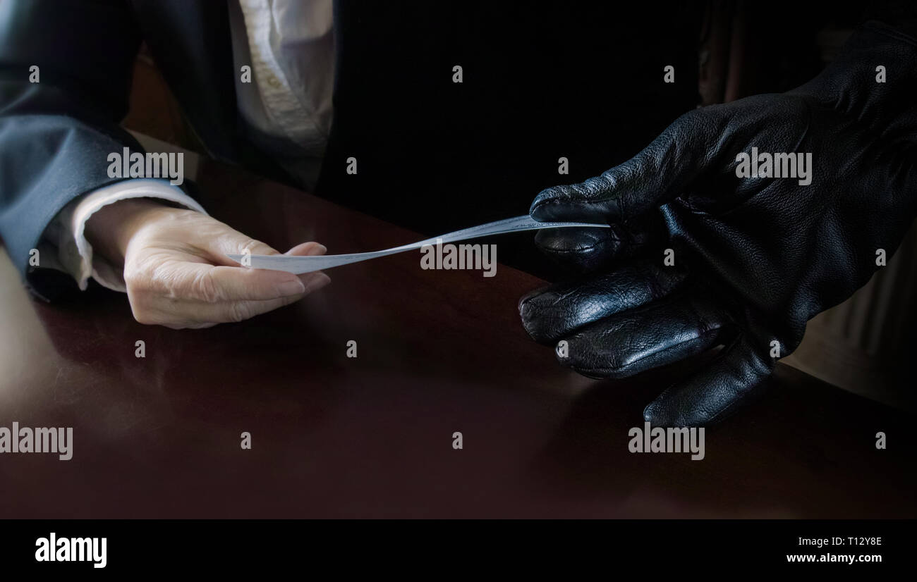 De una mano enguantada a la mano enguantada de una mujer (o lo contrario) pasa un cheque. Foto de stock