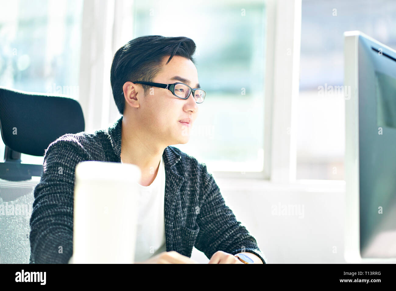 Joven Hombre de negocios asiáticos trabajan en Office mediante el ordenador de sobremesa. Foto de stock