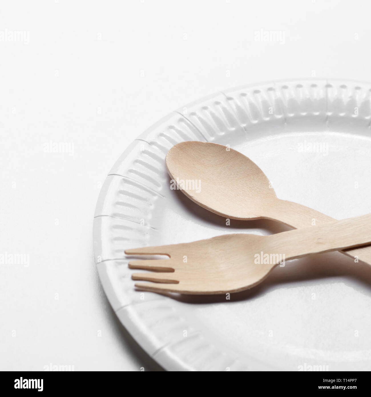 Menaje de un solo uso de madera y papel en la placa de fondo blanco  Fotografía de stock - Alamy