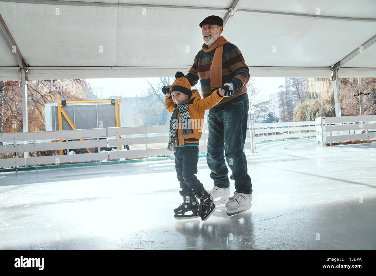 Abuelo y nieto en la pista de patinaje sobre hielo, patinaje sobre hielo Foto de stock