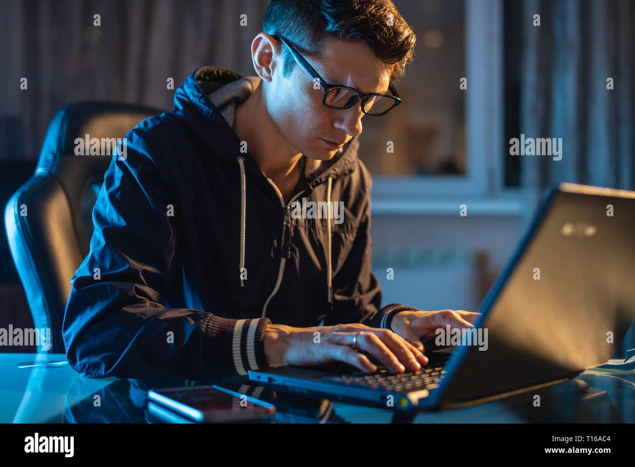Un Hombre Con Anteojos Trabaja En Un Computador Por La Noche Foto