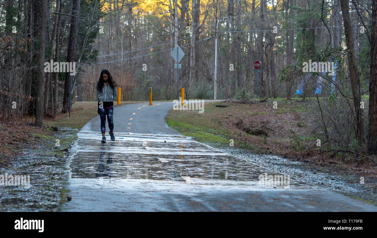 Mujer caminando en el camino después de la tormenta, con charcos y  reflexiones en primer plano Fotografía de stock - Alamy