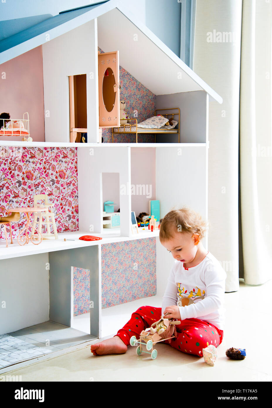 imagen retroiluminada de niño jugando con casa de muñecas y juguetes de  animales rellenos, sentado en azulejos, suelo en casa solo con chupete en  la boca Fotografía de stock - Alamy