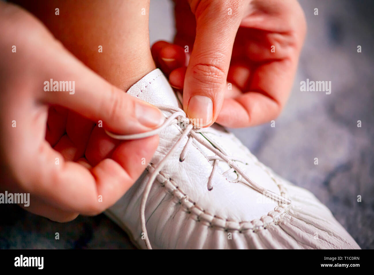 Mujer manos atarse los cordones de zapatos blancos. Close-up Fotografía de  stock - Alamy