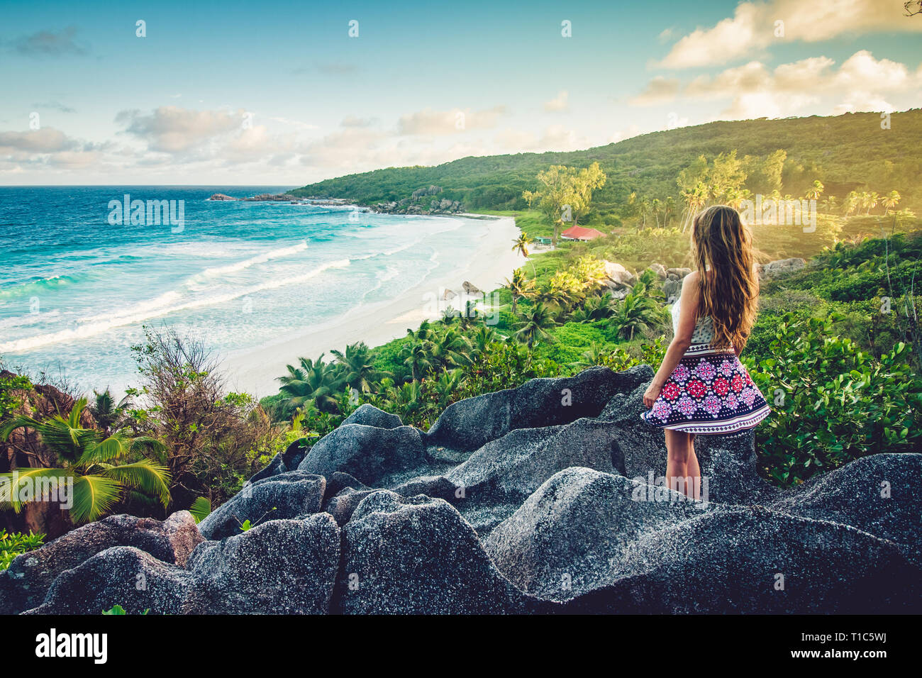 Una chica joven admira la vista en Grande Anse Beach ubicado en la isla de La Digue, Seychelles Foto de stock