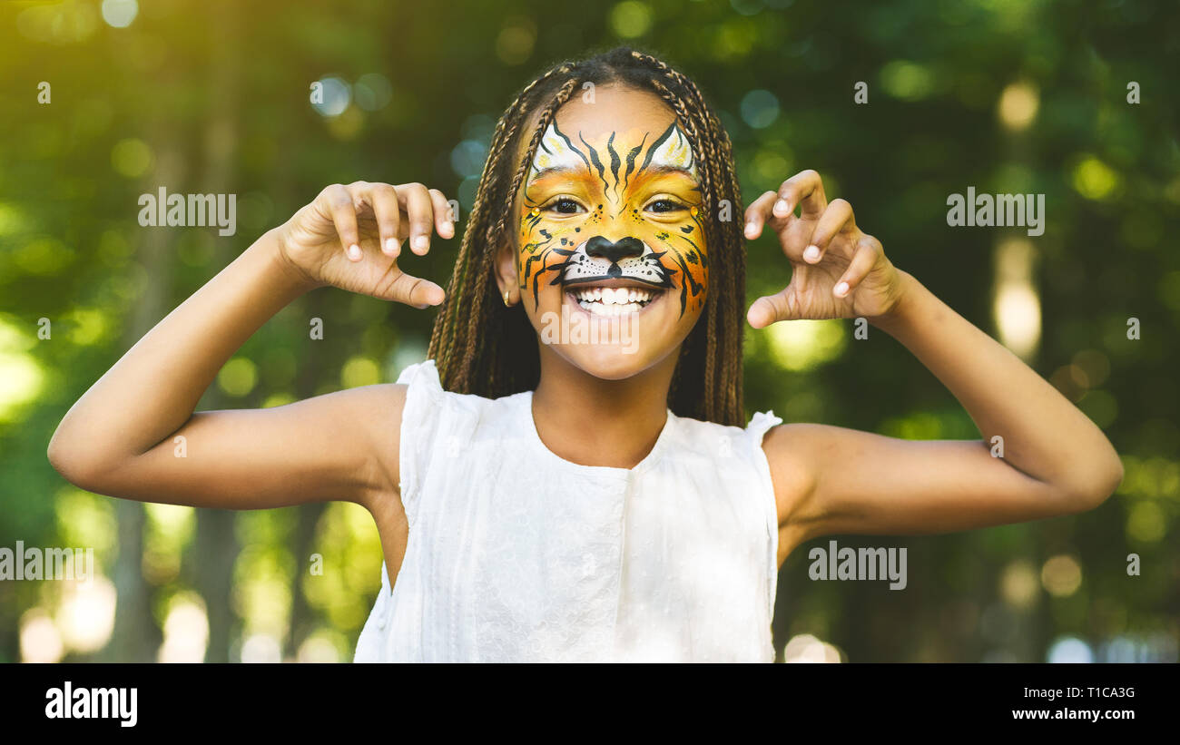 Alegre poco africano-americanos chica con pintura de cara como tiger Foto de stock