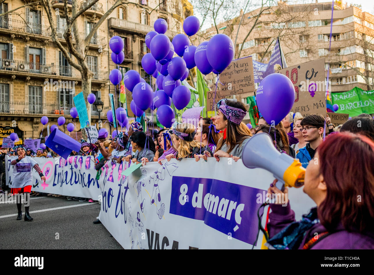Barcelona, España - 8 de marzo de 2019: las mujeres cantando y calpping en la ciudad durante el día de la mujer con globos púrpura Foto de stock