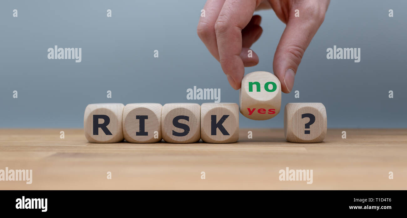 Asumiendo un riesgo? La mano se convierte un dados y cambia la palabra 'sí' a 'no'. Foto de stock