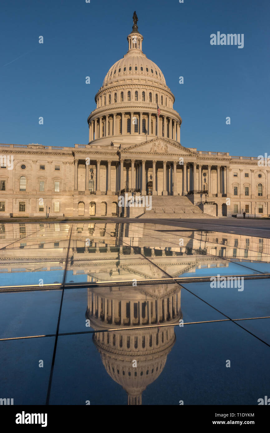 US Capitol; frente oriental reflejando en el sol por la mañana temprano. Reflexión sobre el techo de cristal del metro Capitol visitor center. Foto de stock