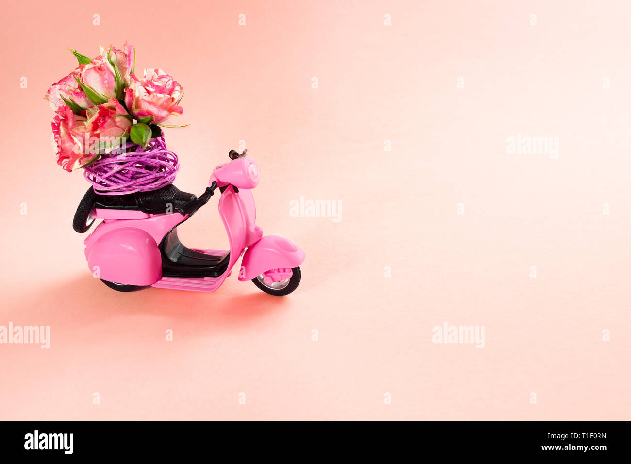 Ramo de Rosas en canasta en el backseat del scooter lindo color rosa sobre  fondo de color rosa. Entrega de flores Fotografía de stock - Alamy