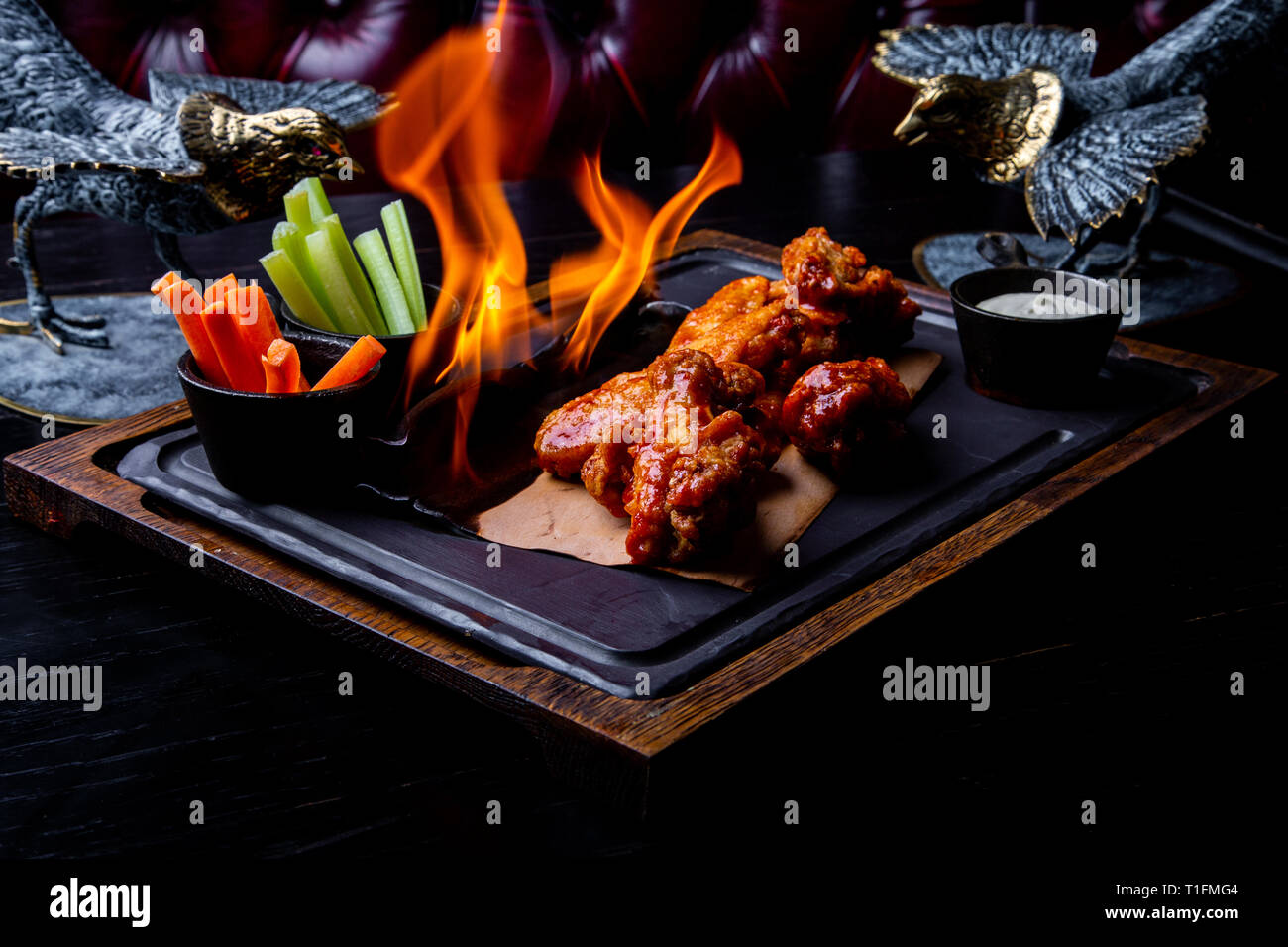 Deliciosos pedazos de alas de pollo a la parrilla con llamas. Restaurante  sobre fondo negro. Barbacoa y parrilla. Restaurante dish Fotografía de  stock - Alamy