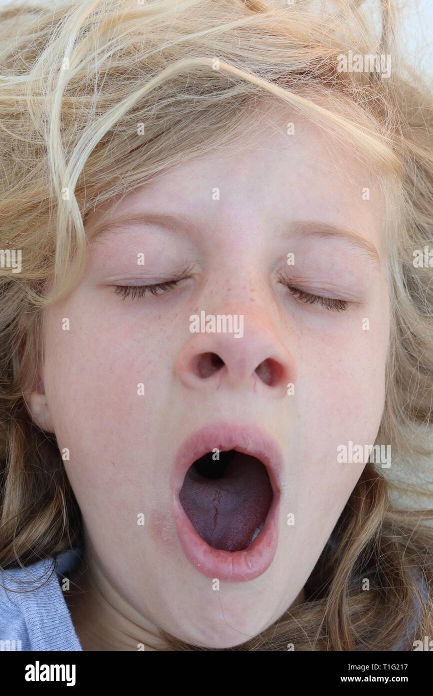 Retrato de una niña con acústico bostezar con los ojos cerrados despertarse Foto de stock