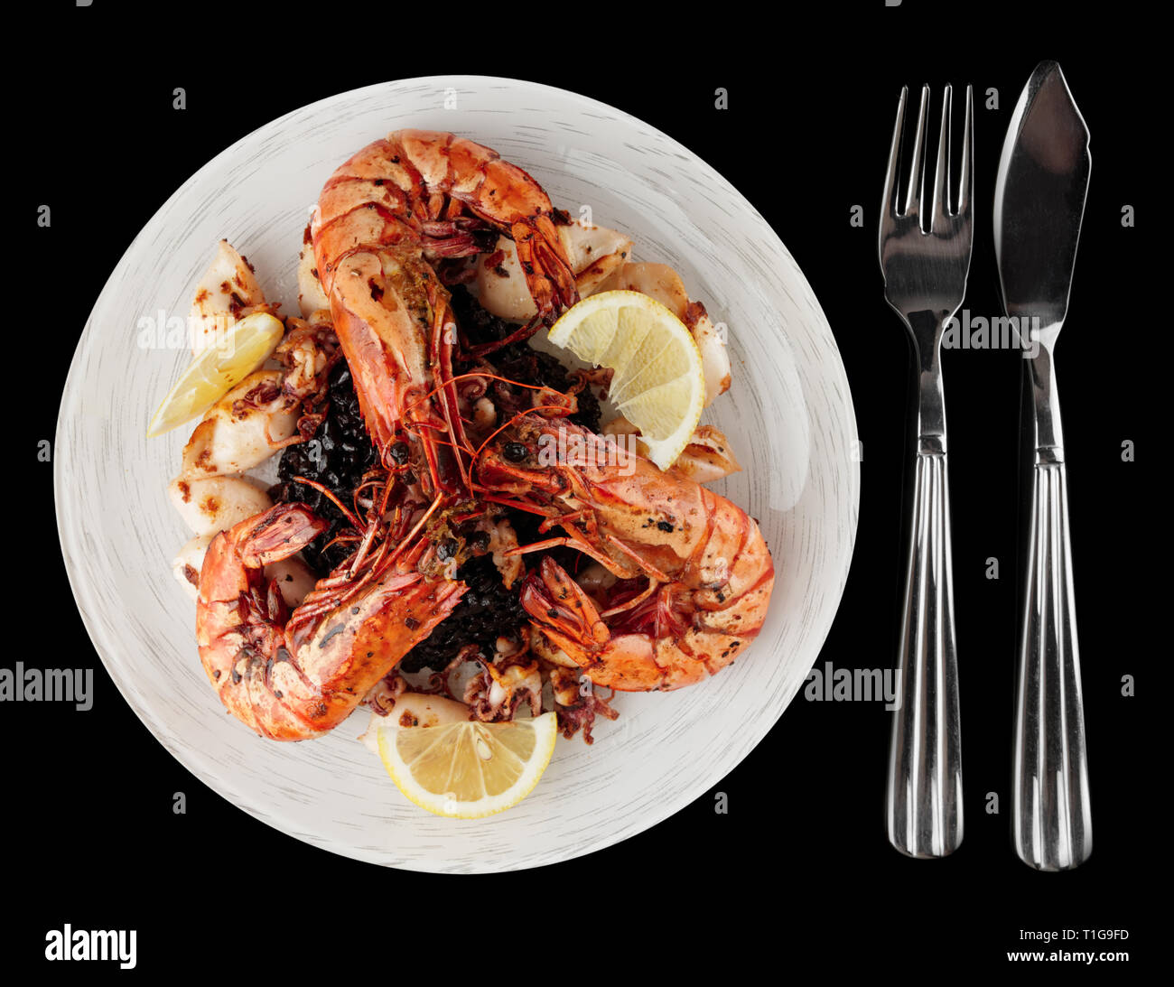 Gambas a la plancha y calamares con arroz negro aislado sobre fondo blanco Fotografía de stock Gambas a la plancha y calamares con arroz negro aislado sobre fondo blanco Fotografía de stock