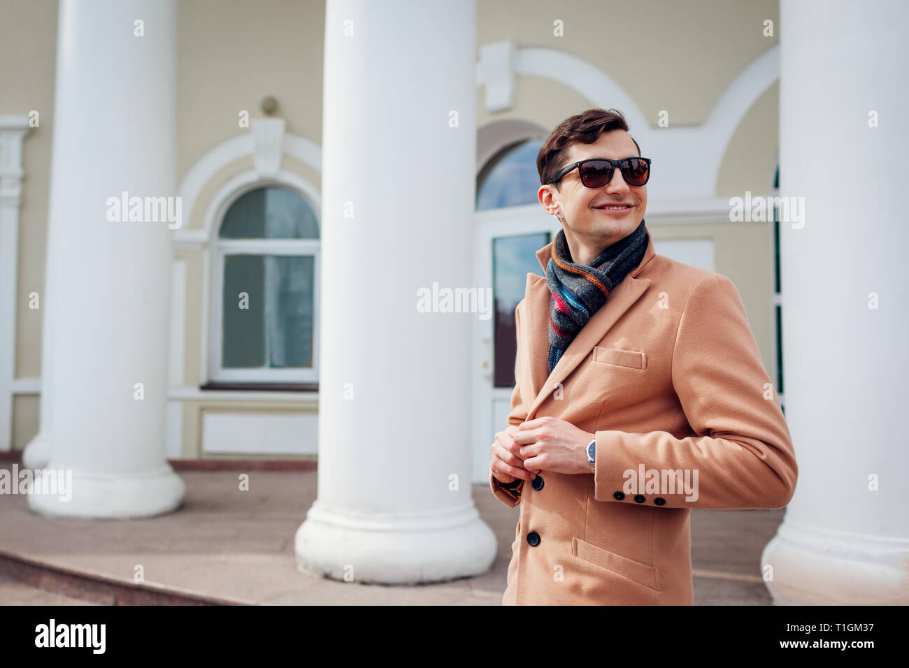 Elegante joven hombre caminando en la ciudad. Guapo vistiendo ropa clásica  y accesorios. La moda de la calle. Hombre botones de fijación Fotografía de  stock - Alamy