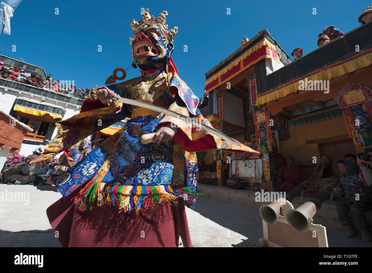 Mahakala de máscara con una gran espada realiza el Cham bailar en un monasterio budista. Foto de stock