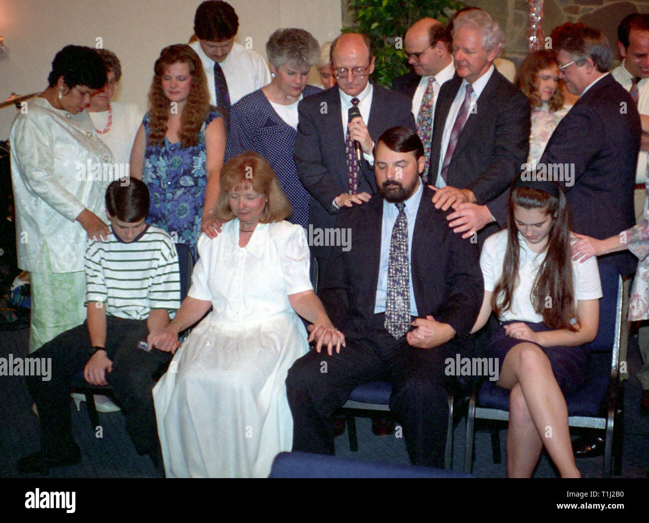 Varias personas rezan por una familia que atraviesa momentos difíciles Foto de stock