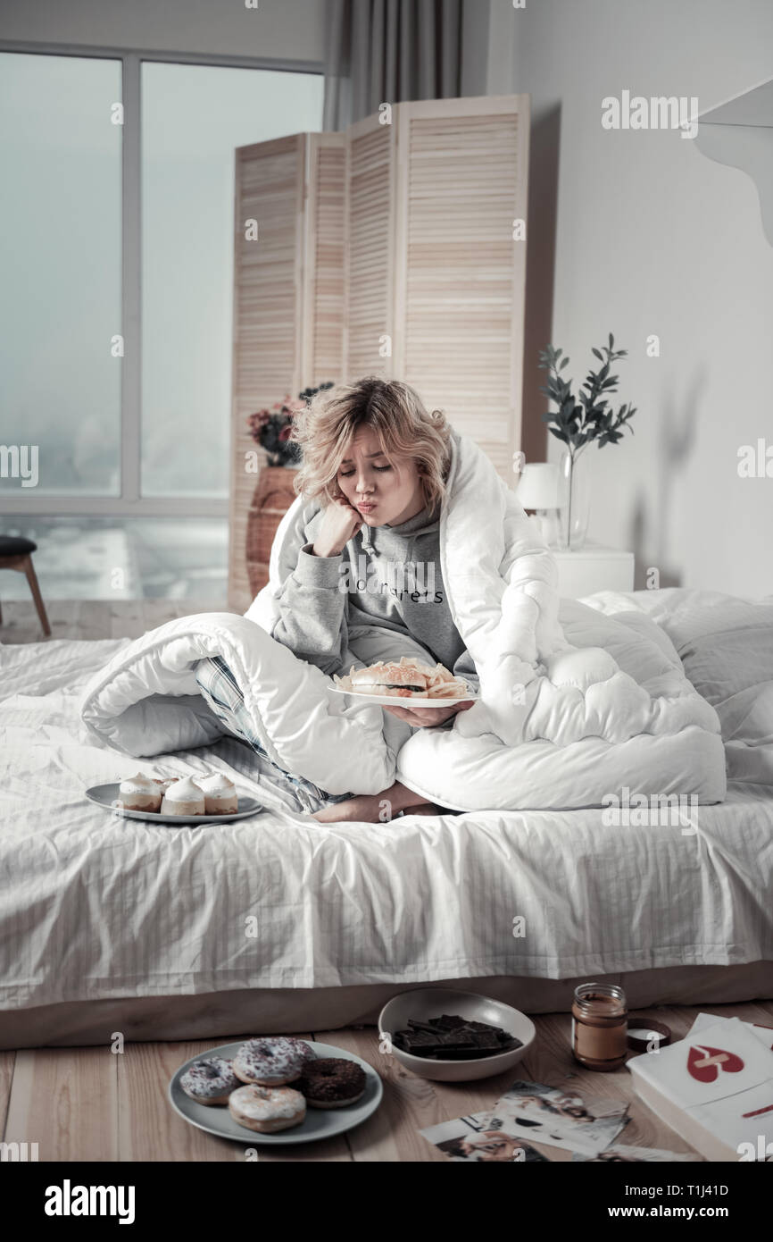 Mujer con el corazón destrozado de no salir de su cama, mientras que tener  depresión Fotografía de stock - Alamy
