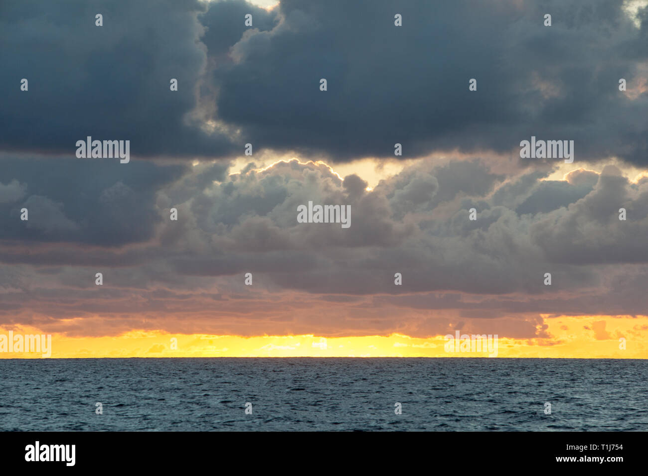 Un hermoso amanecer ilumina las nubes flotan sobre el Mar Caribe. Foto de stock
