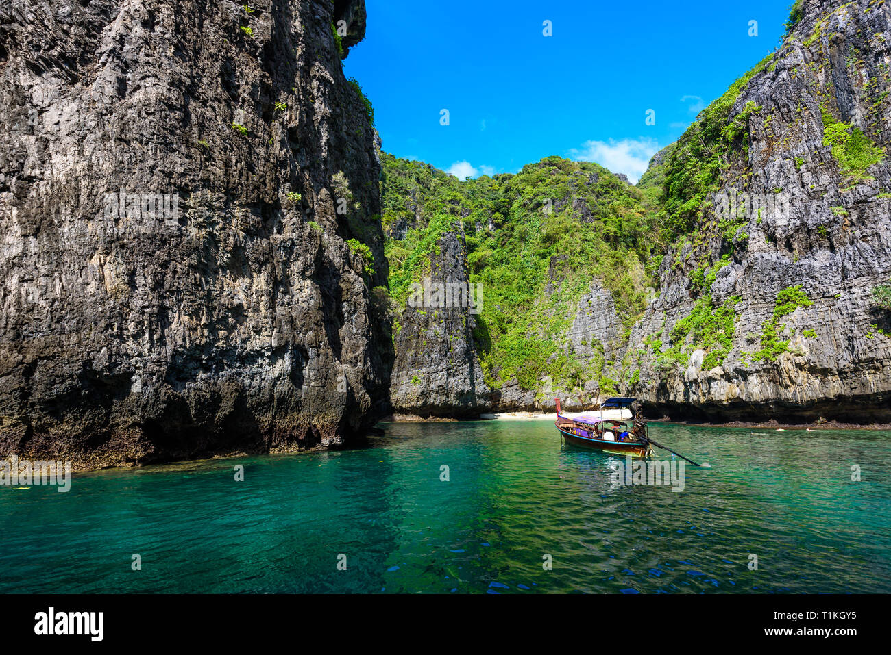 Wang Long Bay con cristalinas aguas turquesa de la isla tropical de Koh Phi Phi Don, en la provincia de Krabi, Tailandia - Lancha en la hermosa laguna con cubierta de rocas Foto de stock