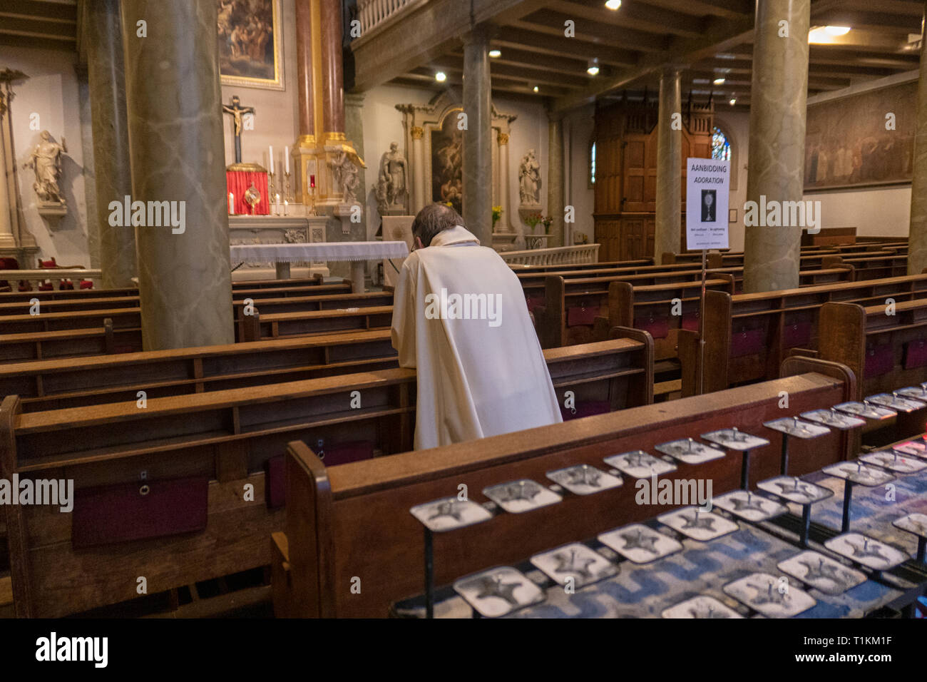Sacerdote reza en el Begijnhof capilla, dedicada a San Juan y Santa Úrsula en Amsterdam Foto de stock