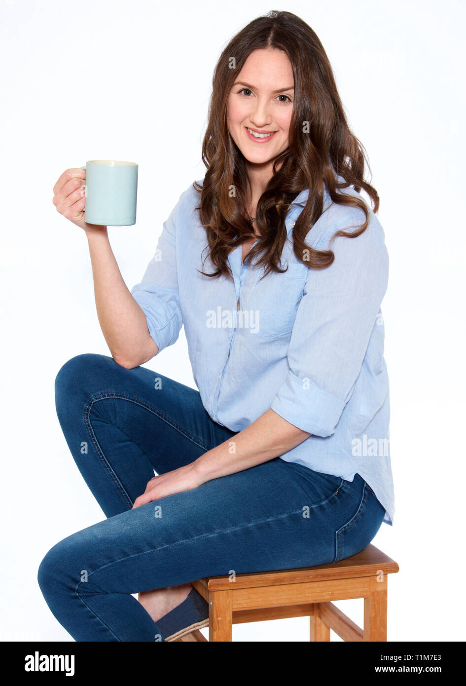 Mujer de treinta años con cabello oscuro y sosteniendo una taza Foto de stock