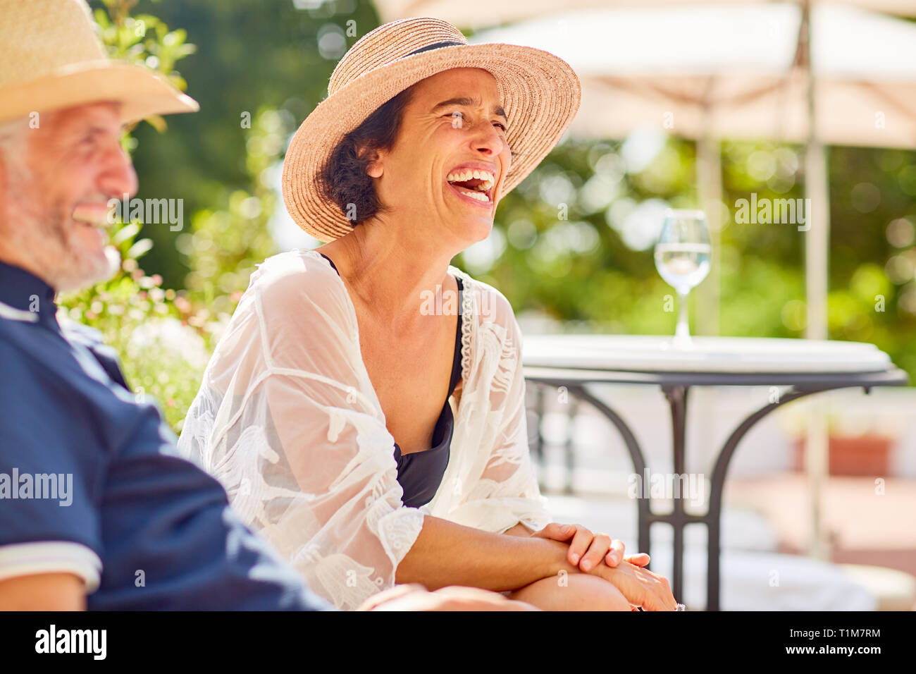 Mujer riendo en el soleado complejo turístico de la piscina. Foto de stock