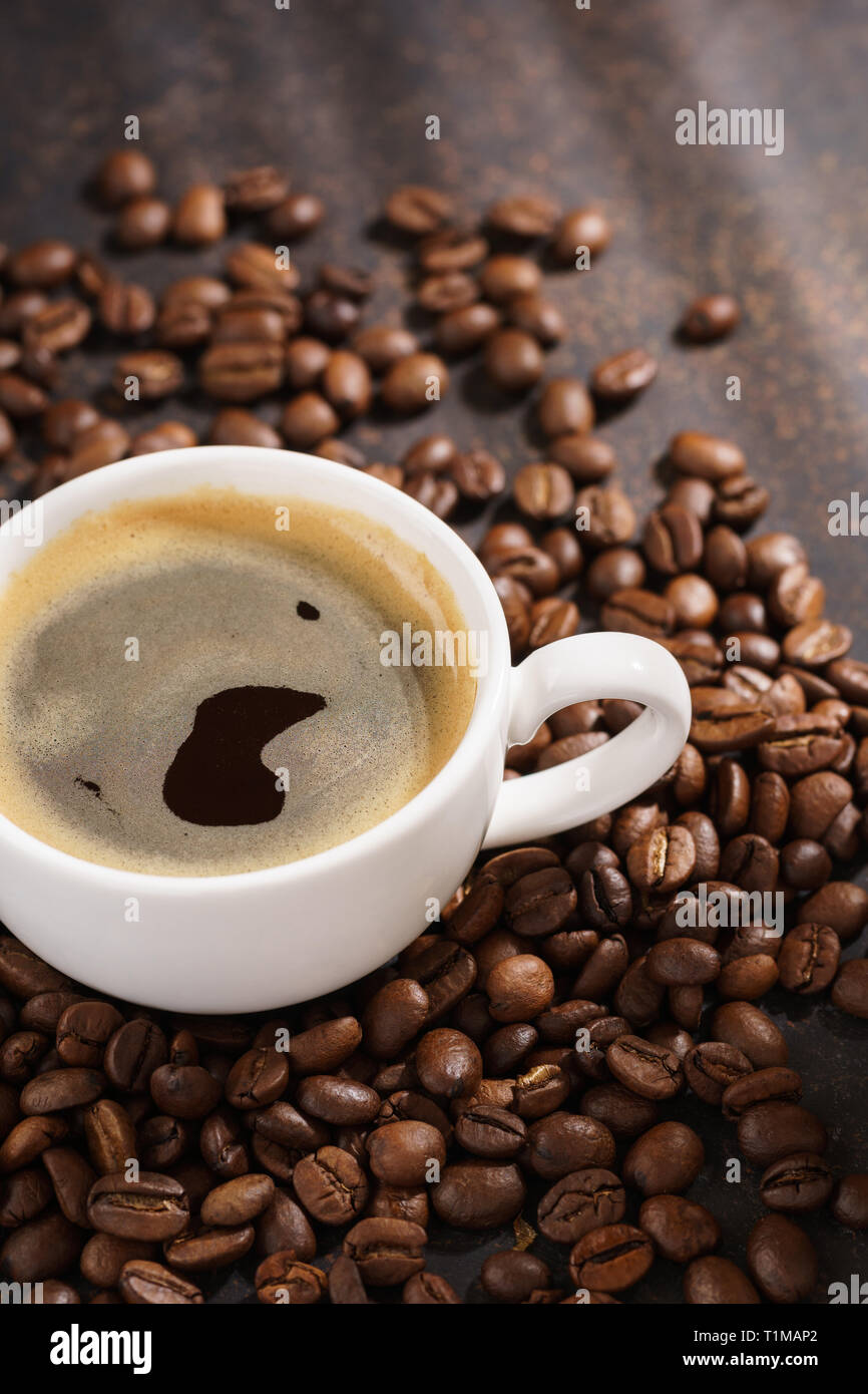 Taza de café tostado en grano. Fondo oscuro con rayos de sol Fotografía de  stock - Alamy