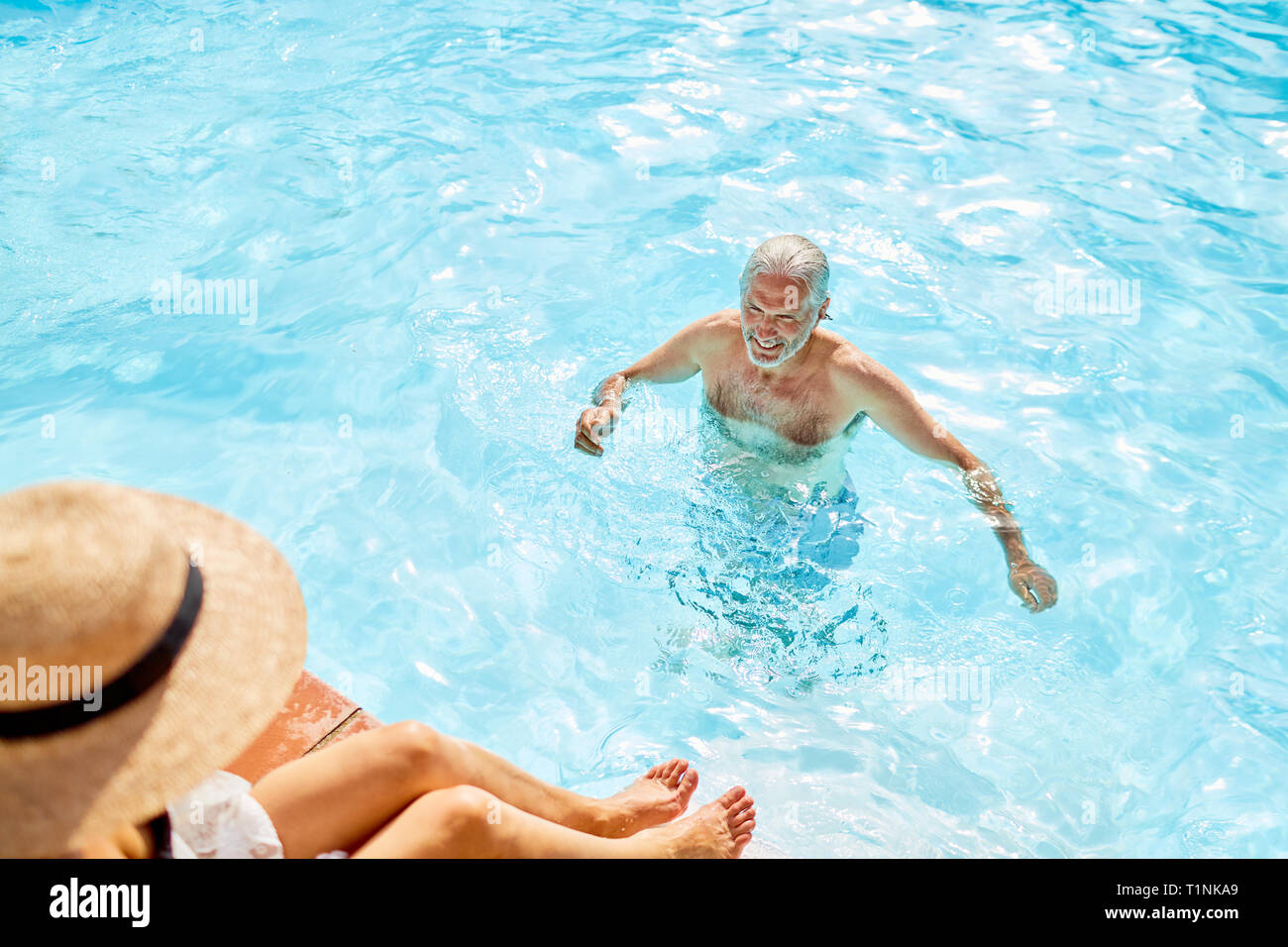 Hombre maduro en la soleada piscina de verano Foto de stock