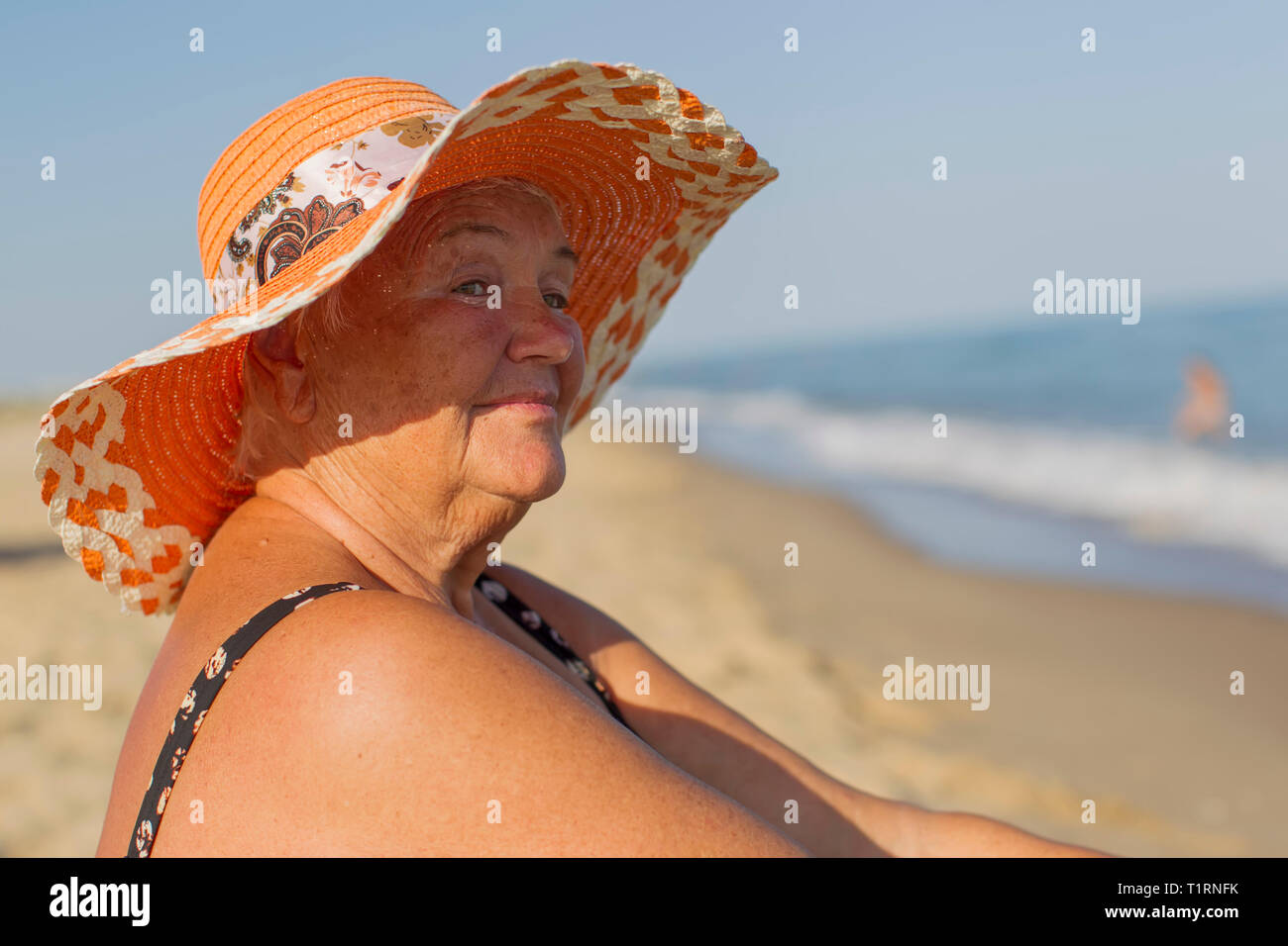 Abuela en vacaciones. Anciana en un traje de baño en el mar. Anciano  sentado en la playa Fotografía de stock - Alamy